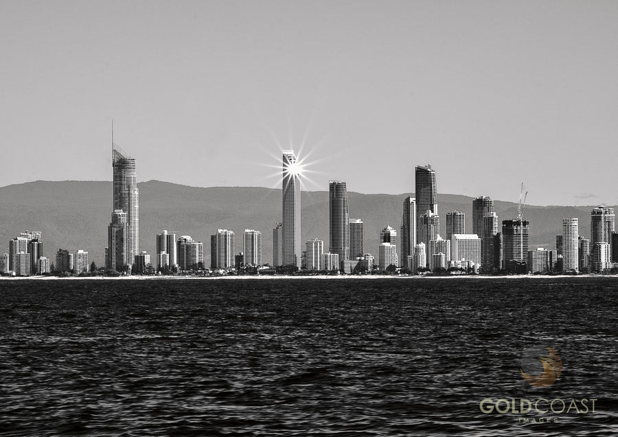 Gold Coast city skyline from the ocean with a starburst of sunlight from a skyscraper